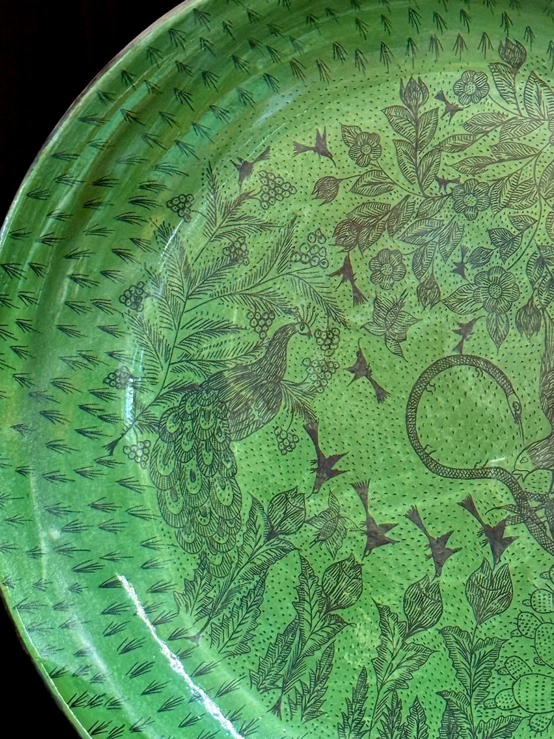 A large green Huáncito platter drawn with a peacock, flowering branches and small birds