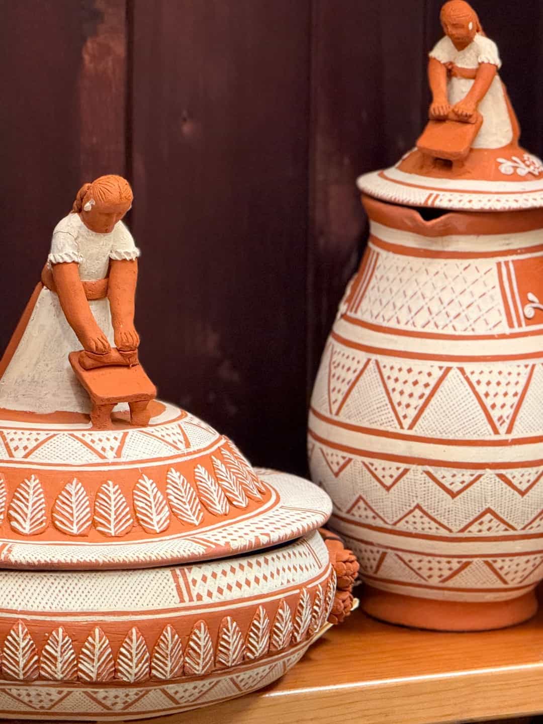 Two lidded Patambán pieces, each finished with a seated figure at work where a knob would usually sit