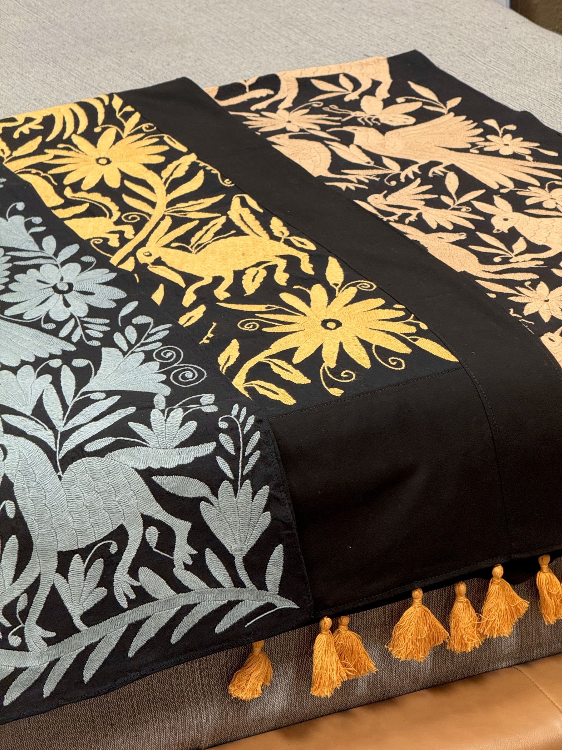 Tenango-embroidered table and bed runners from Hidalgo, finished with gold tassels